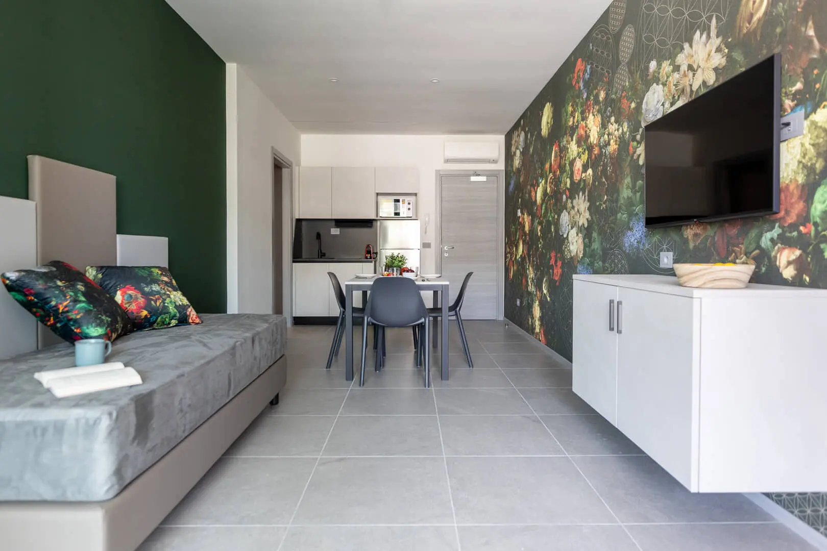 Bilocale moderno con parete floreale.