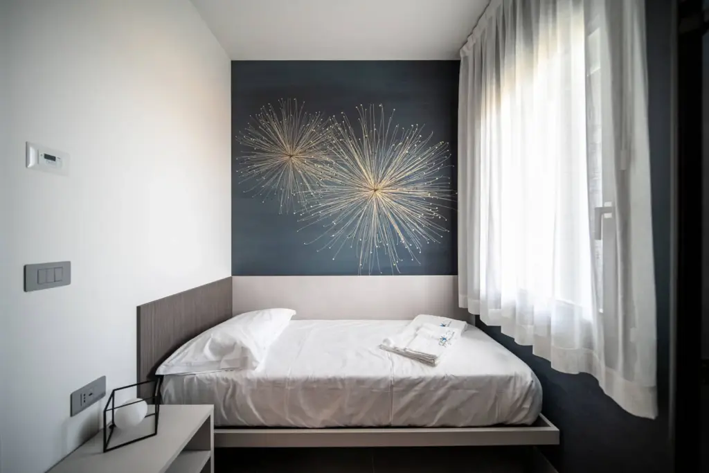 Letto singolo in camera con decorazione murale.