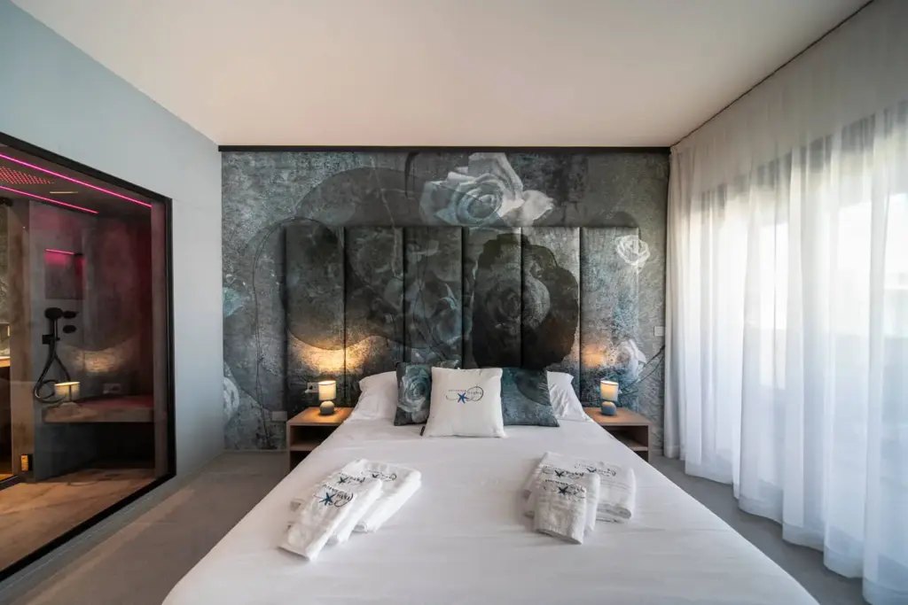 Camera moderna con letto, illuminazione soffusa e bagno annesso.