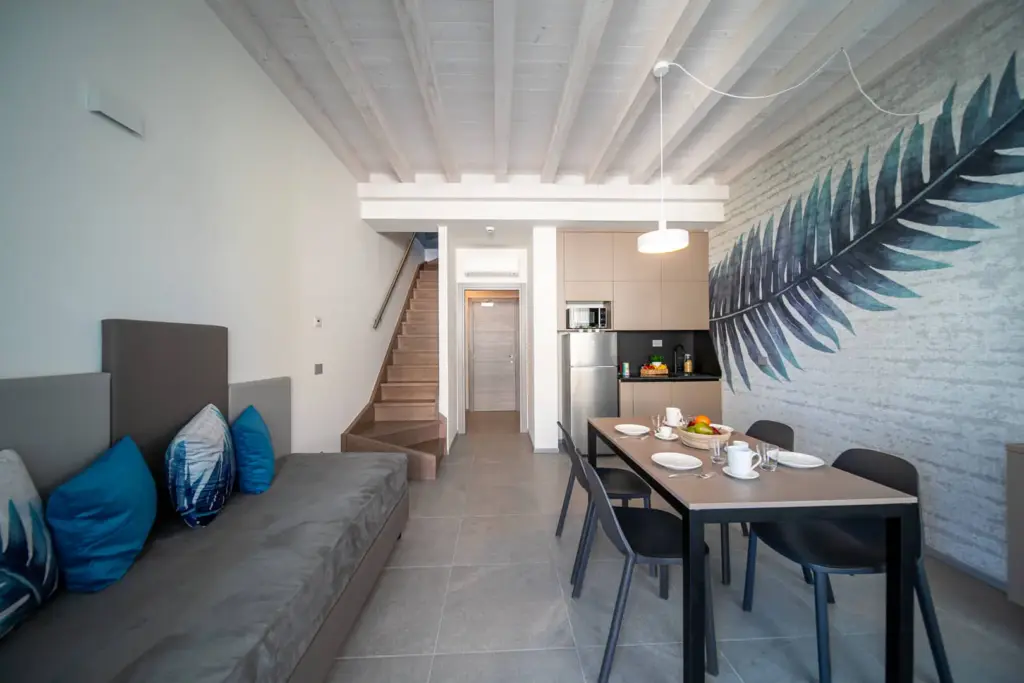 Moderno appartamento con soggiorno, cucina, scala e decorazione murale.