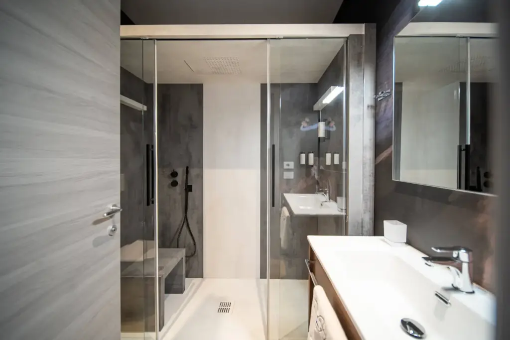 Moderno bagno con doccia in vetro e lavabo bianco.