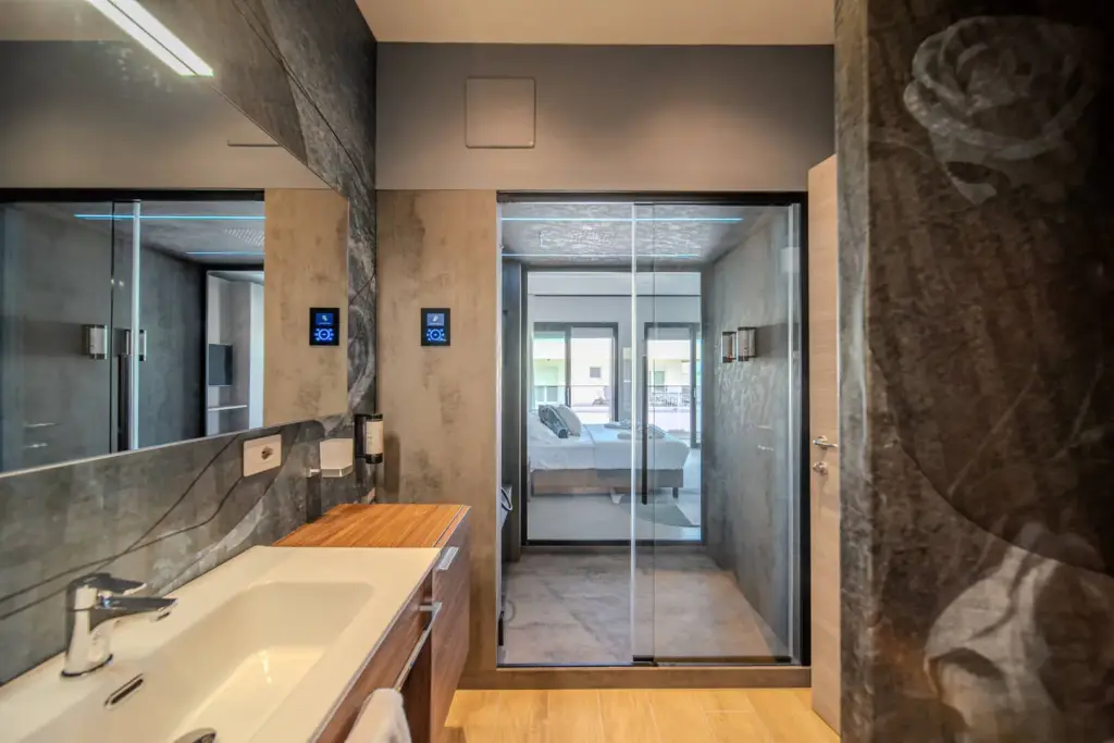 Bagno moderno con vasca e accesso alla camera.