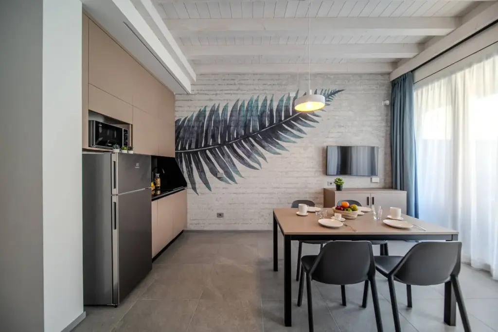 Cucina moderna con tavolo, sedie, frigorifero e decorazione.