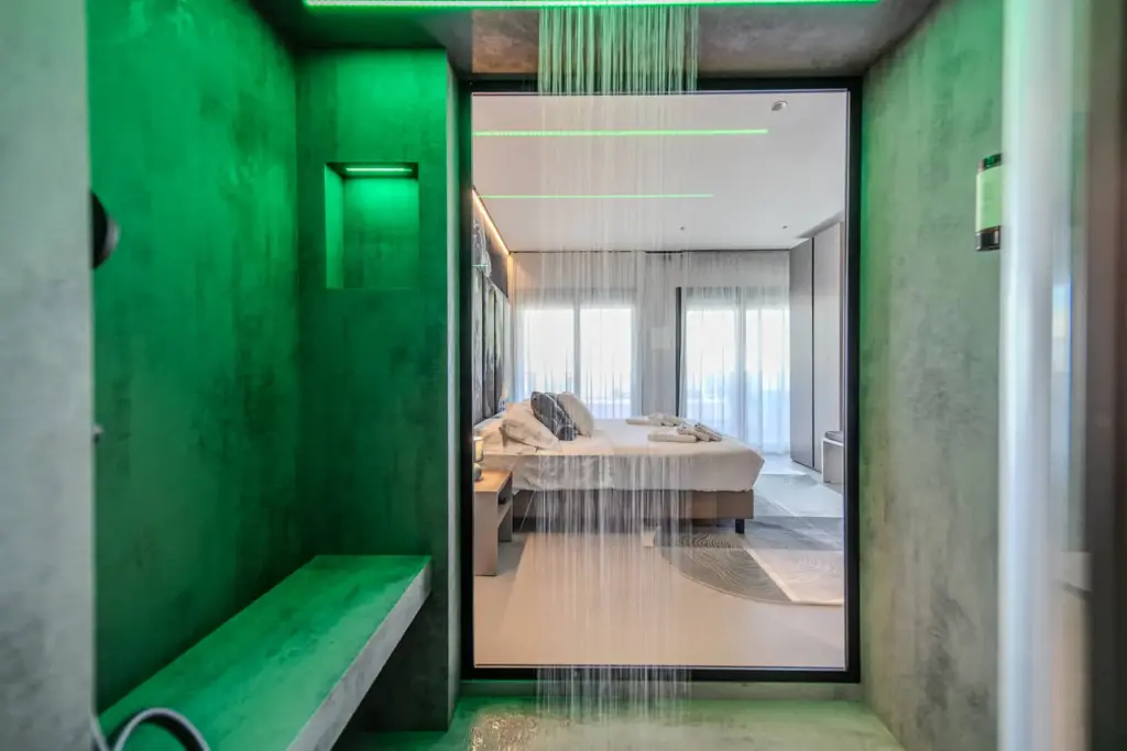 Doccia moderna in camera da letto con illuminazione verde.
