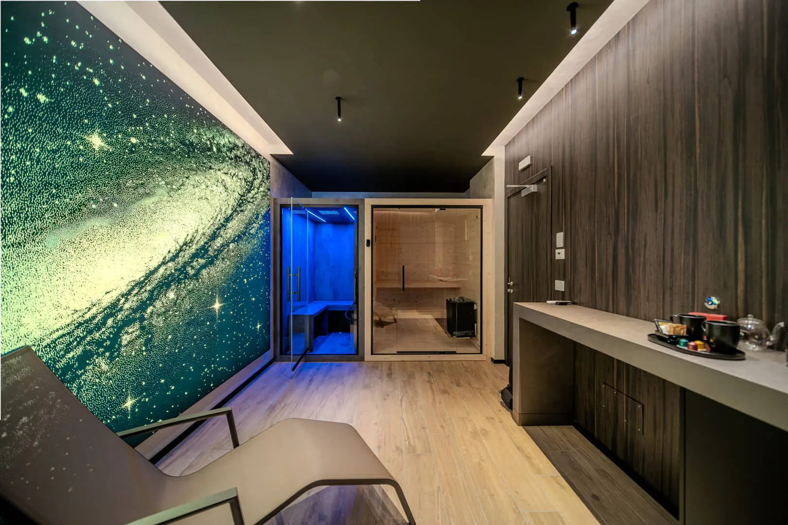 Sala relax con parete galattica e sauna.