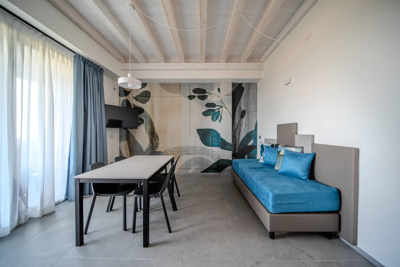 Soggiorno moderno con divano blu e tavolo elegante.